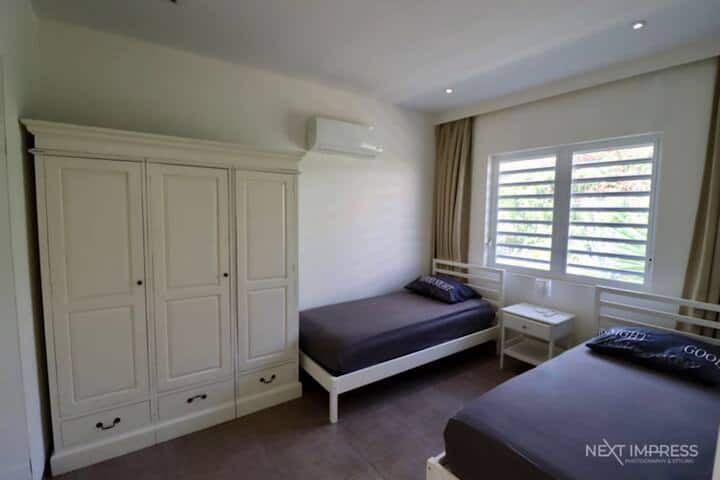 Chumba cha kulala na vitanda viwili vya mtu mmoja na kabati kubwa