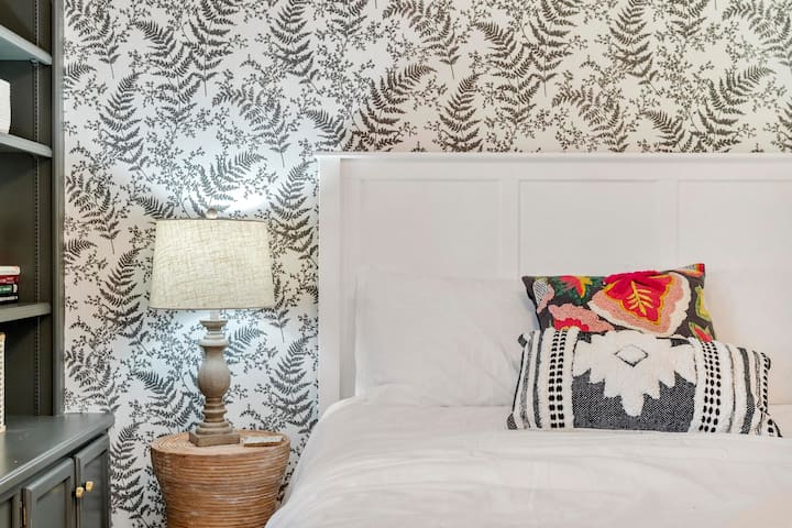 Bračni krevet (160x200) na katu s pametnim televizorom i dvostrukim policama za knjige s prozorima. 