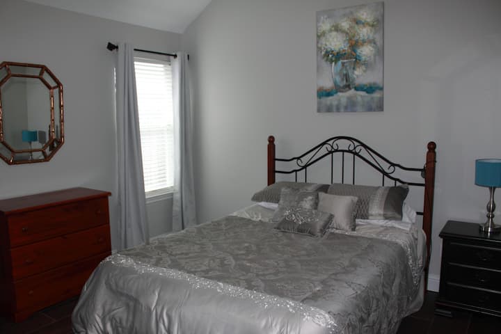 חדר שינה בינוני עם מיטת קווין סייז עם שלט רחוק כדי להעלות את המיטה. 