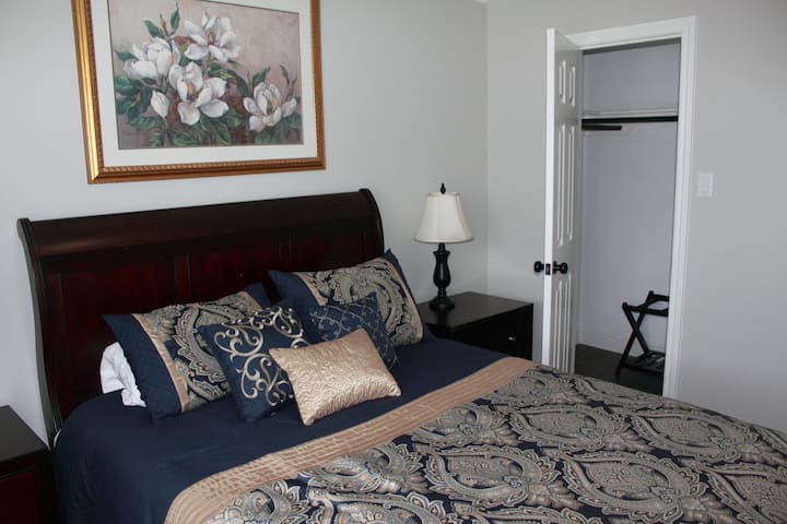 חדר שינה מראש עם מיטת קווין סייז, חדר ארונות וכיסא עם שולחן קריאה