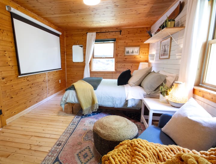 "The Night Owl" bedroom located on the second floor features an 84" movie projector screen. The projector is connected to a Chromecast so you can wirelessly stream your favorite Netflix, Crave, and Prime TV shows and movies. 