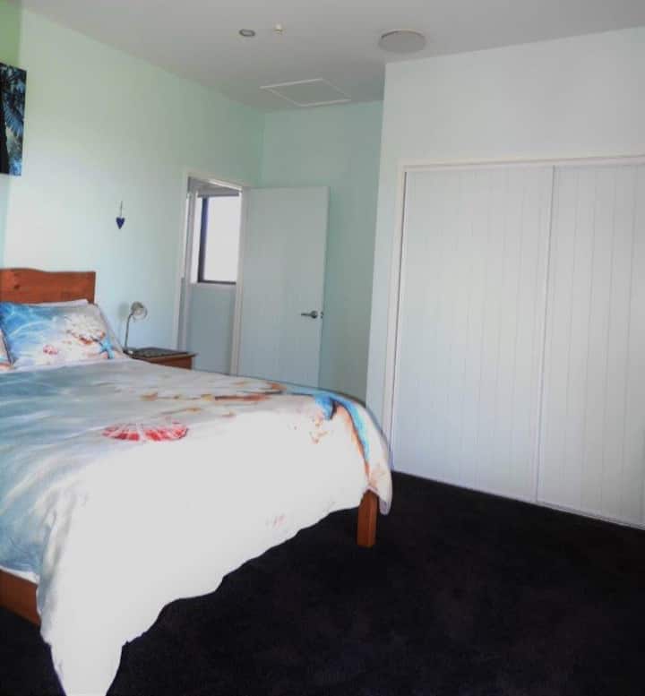 Lit queen size avec vue sur la mer et un accès direct à la salle de bain.