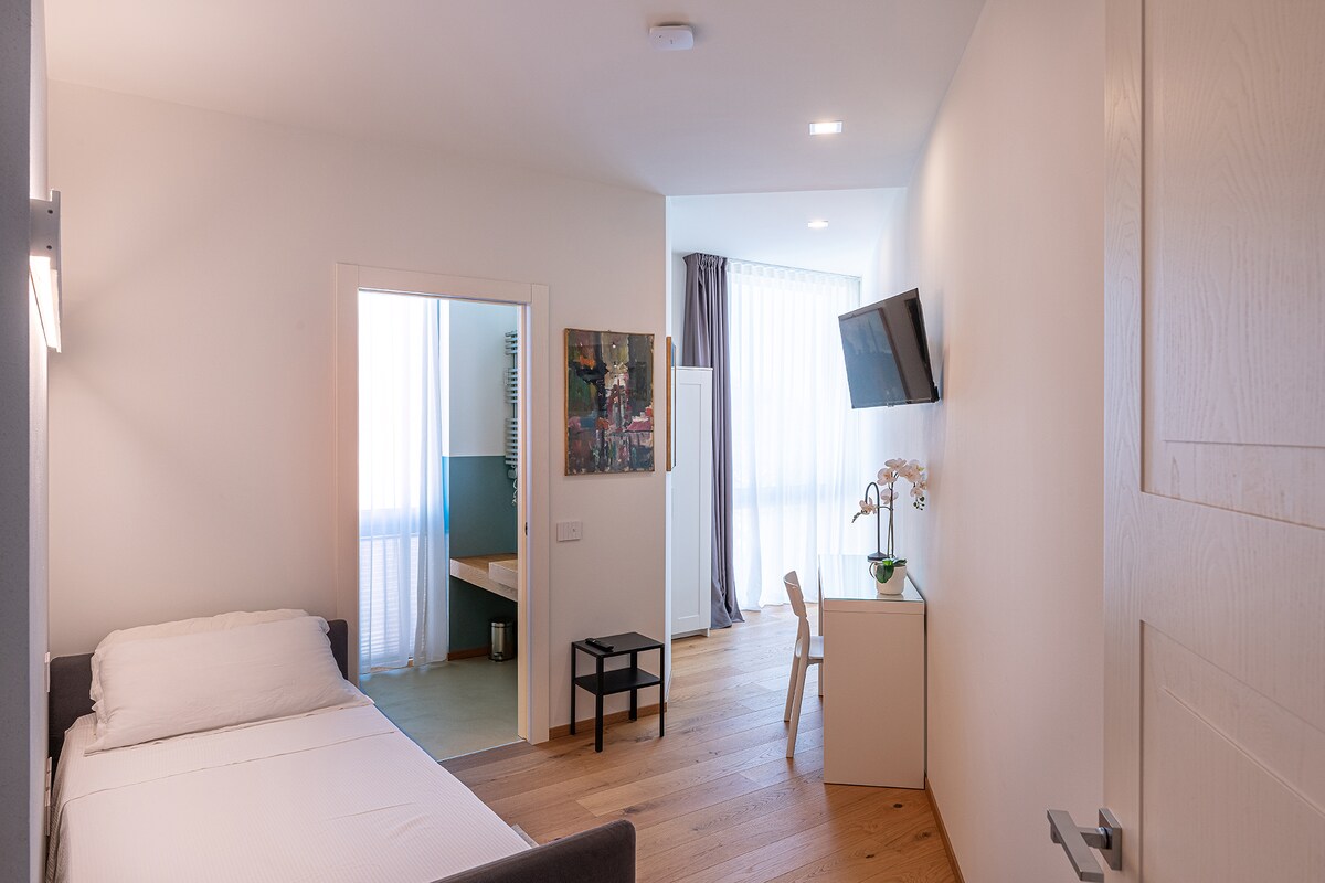 Пространа и удобна еднокреветна соба со кревет, приватна бања и сите удобности: паметен телевизор, биро, плакар и клима уред