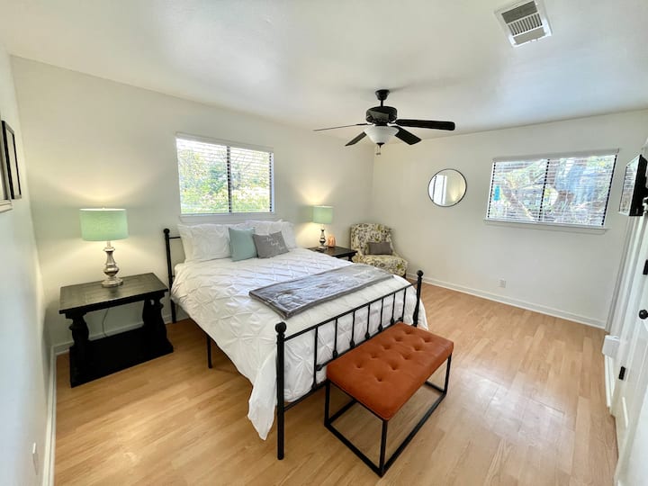 Тази спокойна основна спалня разполага с удобно двойно легло, собствена баня и много естествена светлина. Със спокойни цветове, уютно спално бельо и кът за четене до прозореца, това е идеалното място за почивка в края на деня.