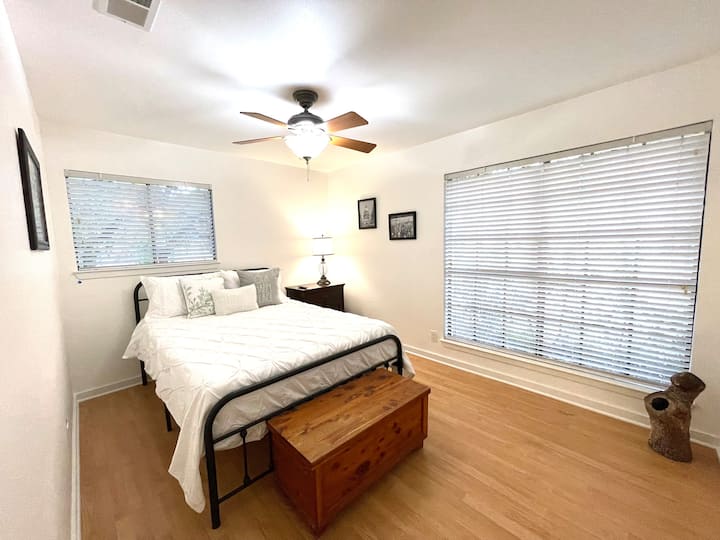 Тази светла трета спалня разполага с уютно легло с размер Queen, големи прозорци с изглед към дърветата и просторен гардероб с вградени шкафове и смарт телевизор за релаксиращи филмови вечери.