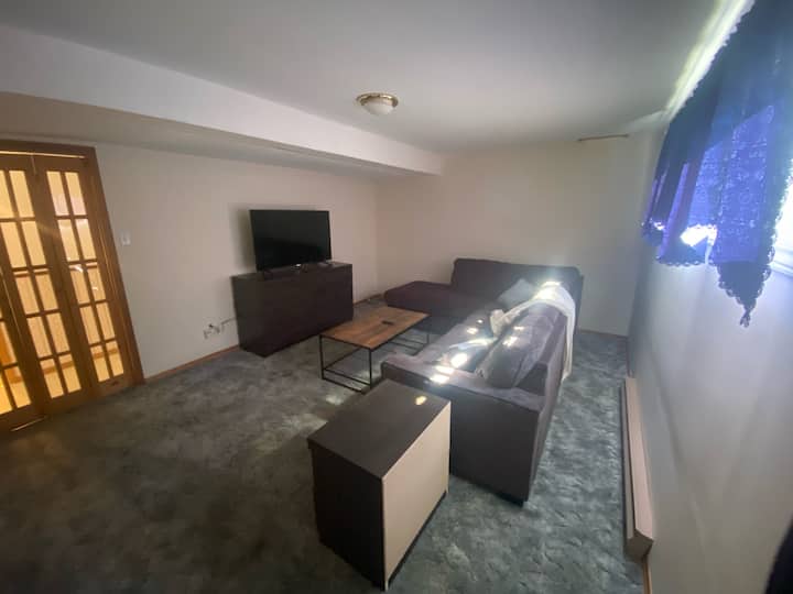 Salle de récréation confortable avec deuxième télévision 4K Roku et lit queen gigogne 