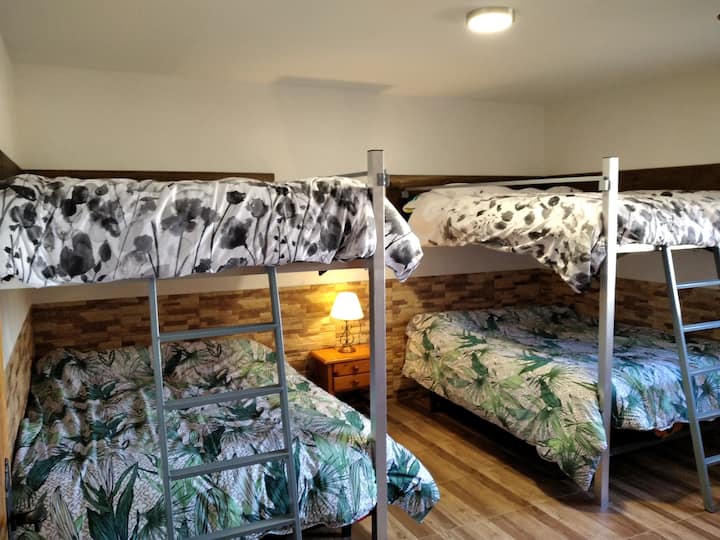 Dormitorio con 4 camas de matrimonio distribuidas en 2 literas.