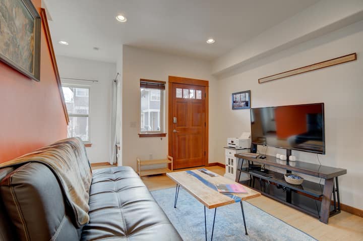 The cozy living room functions as a 3rd sleeping area for a guest, and features cable TV, and a gaming emulator, office printer, and some books.