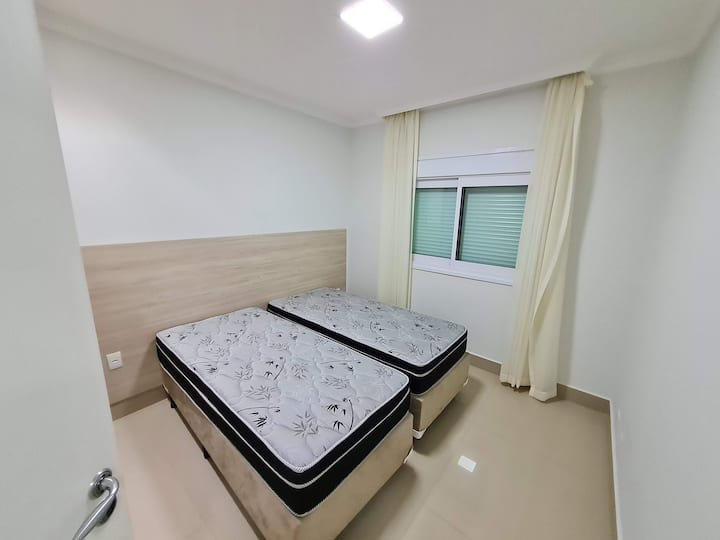 2号卧室配有2张标准单人床（您可以携带床铺并转换为双人床）、空调、电动百叶窗和内置衣柜。
