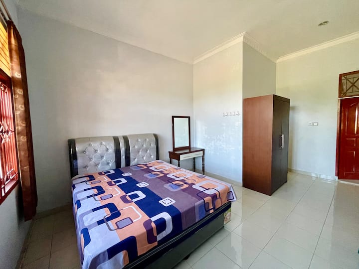 Dormitorio, disponible con cama, ropa de cama, almohadas, armario, escritorio y baño privado.