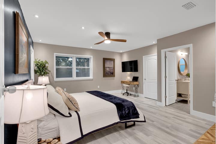 Velika glavna spavaća soba s TV-om i malim radnim stolom.