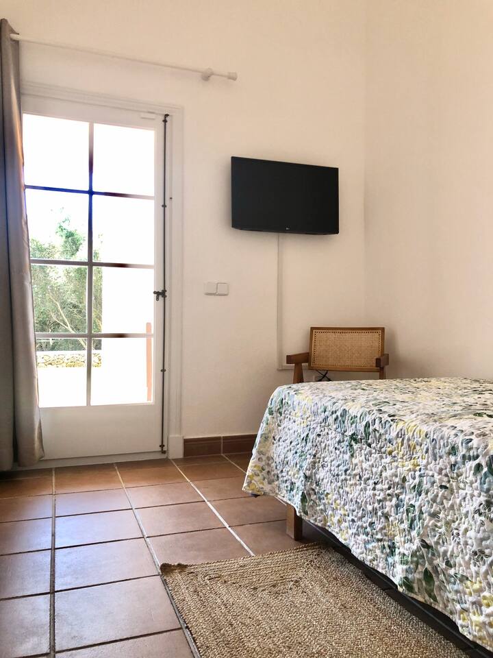 Habitación individual con acceso al jardín., con TV y armario empotrado.