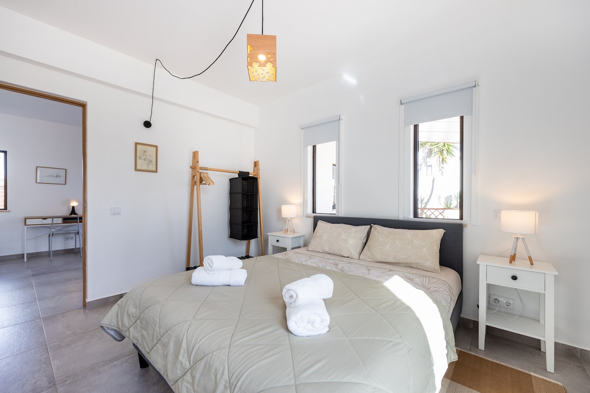 Bedroom with 2 single beds and view to the front yard and terrace