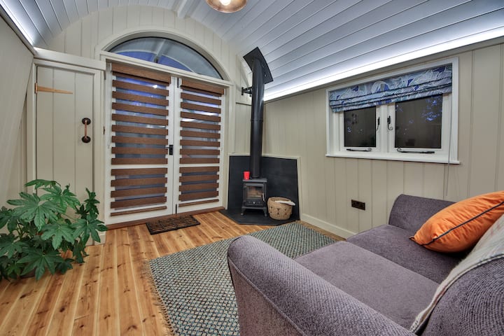 منطقة جلوس (سرير أريكة) مع موقد يعمل بحرق الخشب. الأبواب تؤدي إلى إطلالة على البحيرة.