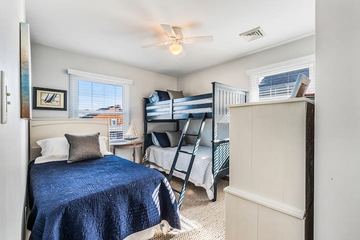 غرفة بطابقين بثلاثة أسرّة فردية وخزانة ملابس وخزانة ملابس