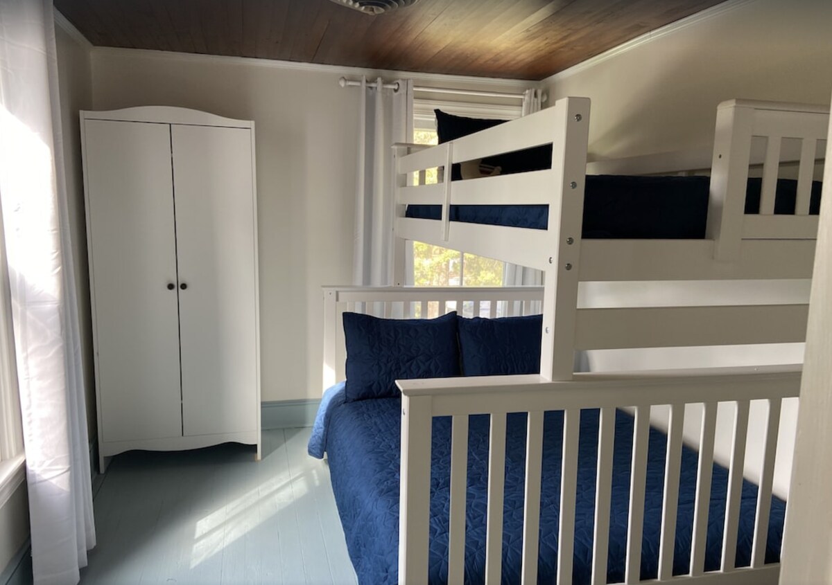 Ორსართულიანი ოთახი პირამიდის ფორმის ორსართულიანი საწოლებით და გამოწიეთ სრული ზომის, გამოსაწევი საწოლი.