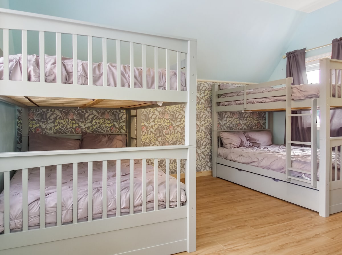 Upstairs bedroom 3 that is loaded to handle up to 10 more guests! It has 4 more full-sized beds, and 2 twin-sized trundle beds. Large roku TV and dresser included in this room as well.