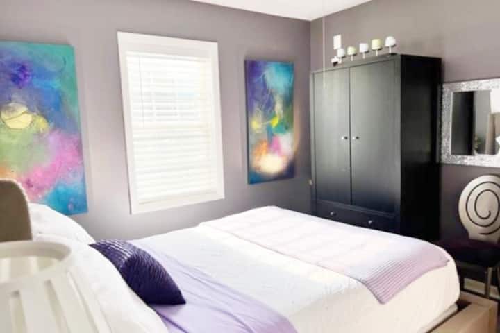 Queen size bed with windows facing West and South with view of the mountains.