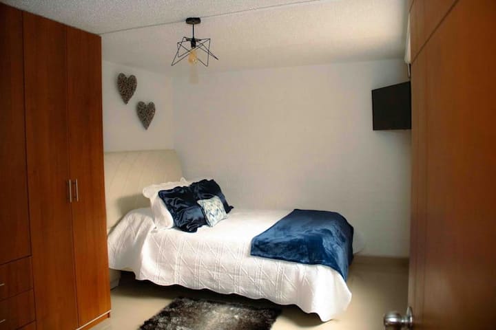 ห้องนอนหลักพร้อมตู้เสื้อผ้าทีวีและห้องน้ำส่วนตัว