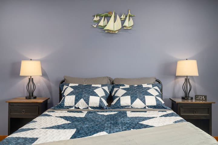 Blue bedroom with queen size memory foam bed.

Touch lamps have USB charging ports accessible on the base. 

Close the blackout shades to sleep in, or open for lots of light and a view of the front pasture.