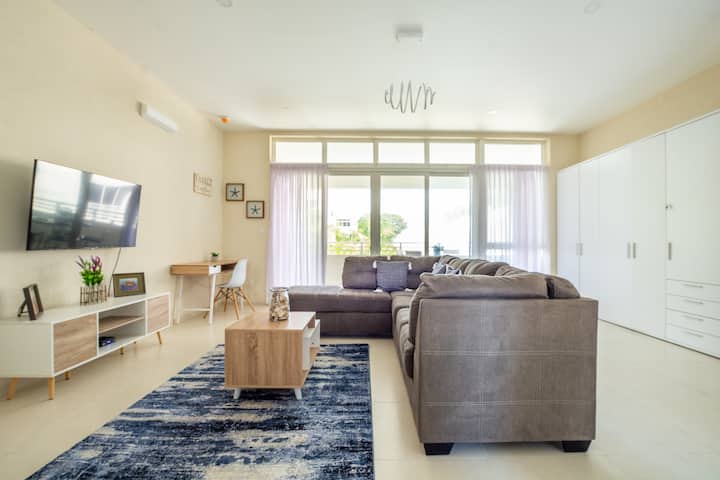 ผ่อนคลายในห้องนั่งเล่นที่กว้างขวางของเราออกแบบมาอย่างพิถีพิถันในโทนสีธรรมชาติที่ผ่อนคลาย มีทีวีขนาดใหญ่ เคเบิล โซฟารูปตัวแอลขนาดใหญ่ และที่เก็บของเพียงพอ 
ที่พักที่น่าอยู่แห่งนี้เต็มไปด้วยแสงธรรมชาติเข้าถึงลานบ้านได้ง่ายเพื่อการพักผ่อนที่ดีที่สุด