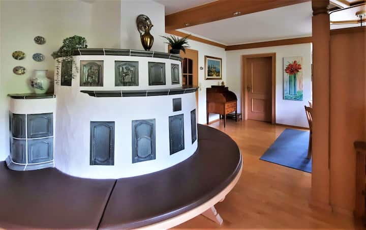 del Landl Naturapartment EschenWald. Acogedora estufa de azulejos con banco en la sala de estar. Disfruta del acogedor calor de los azulejos después de un día frío de esquí. Te calentarás cuando la madera esté agrietada cuando te calientes.