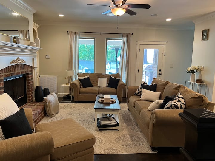 Útulná obývačka otvorená do kuchyne s plynovým kozubom.