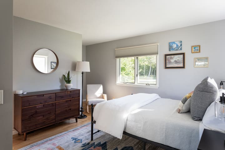 Este extravagante dormitorio en la planta principal tiene una cama queen y obras de arte divertidas con temática de nubes. 