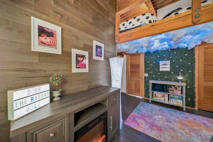 Our Cheshire Cat room sleeps 7 - w/ it’s full bunks + loft space w/ a full a twin. It has cloud lights which sync to Alexa thunder sounds & simulate a lighting storm. In addition to a electric fire place, private patio & attached Jack & Jill bathroom
