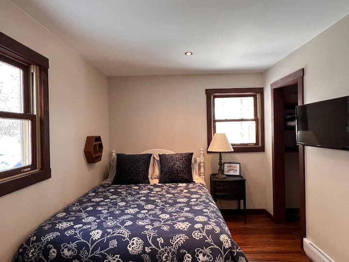 חדר שינה בקומה הראשית עם מיטת קווין סייז וארון. 