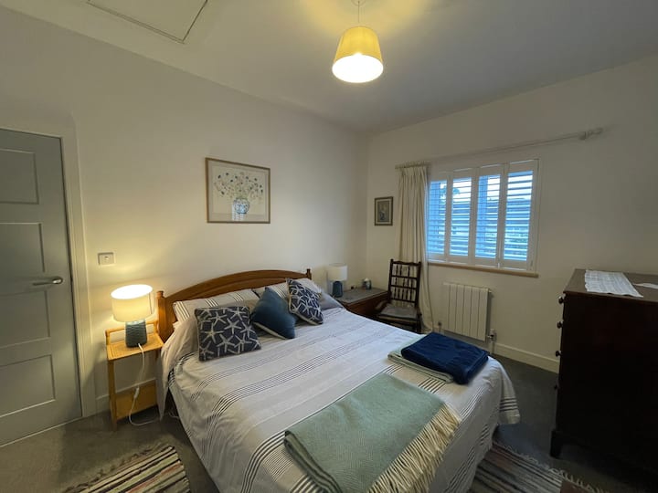 Dormitorio 1: cama tamaño king, armario, cómoda y silla junto a la cama con vistas al pueblo al campo circundante.