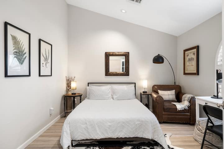 ห้องนอนด้านหน้ามีเตียงควีนไซส์และโต๊ะทำงานพร้อมจอภาพคู่สำหรับพื้นที่ทำงาน