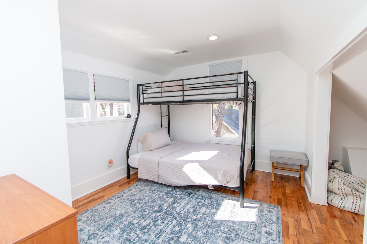 تحتوي غرفة النوم الغربية على سرير بطابقين مع سرير مزدوج وكامل الحجم.