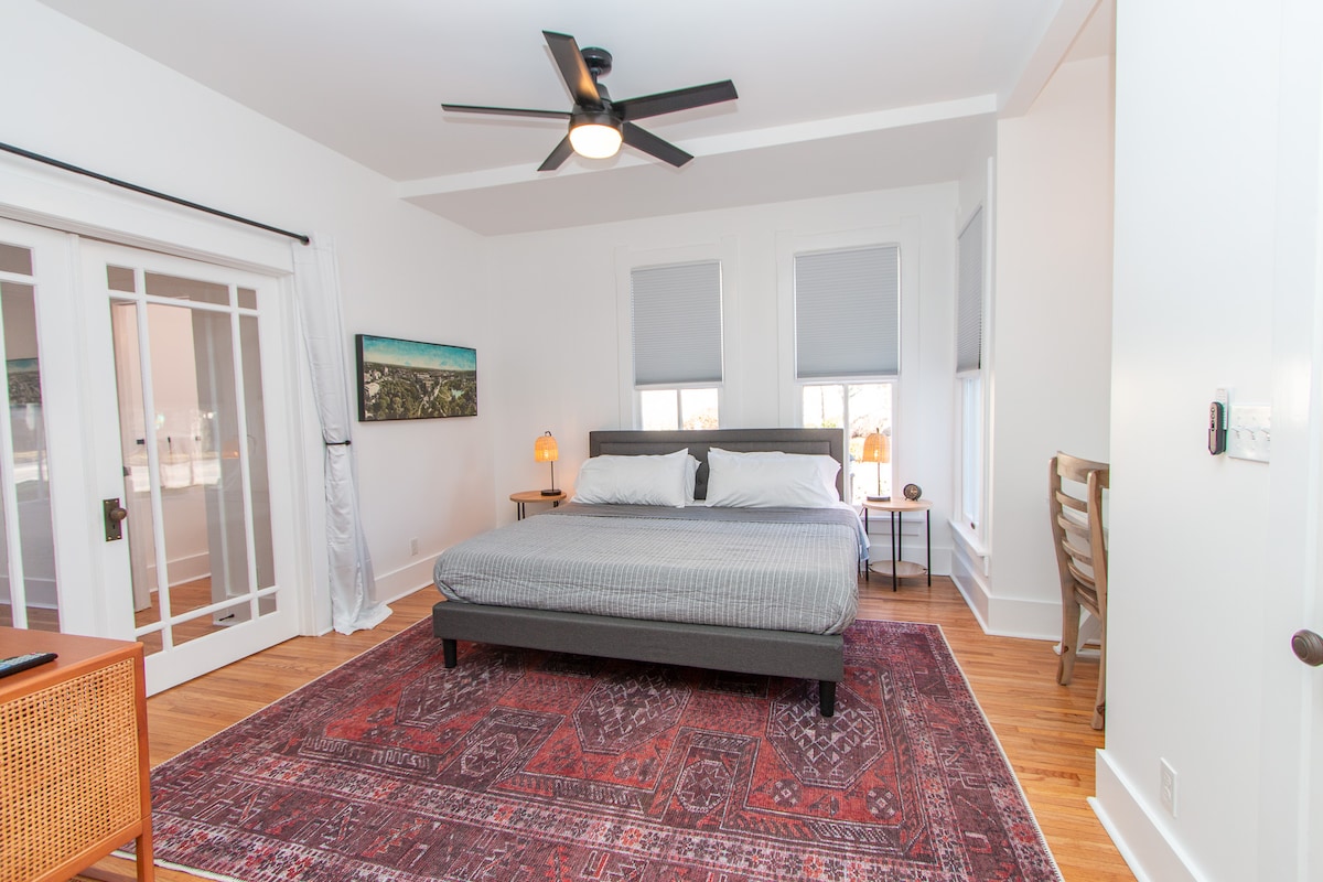 جناح أساسي لغرفة النوم يحتوي على سرير بمقاس كبير ومساحة عمل وحمام كامل.