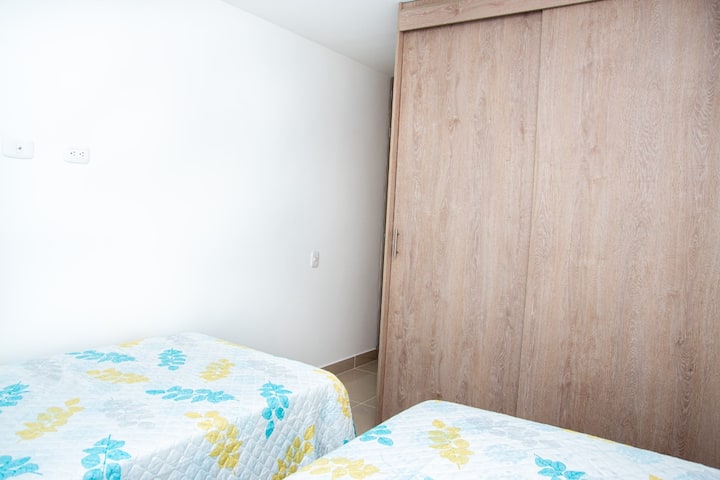 Cuarto con dos camas sencillas, un closet y aire acondicionado