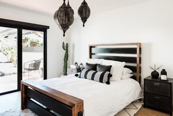El dormitorio principal cuenta con una cama queen size y una puerta La Catina que da a la terraza española con azulejos y al jacuzzi. La habitación tiene persianas opacas motorizadas y una chimenea de gas transparente.