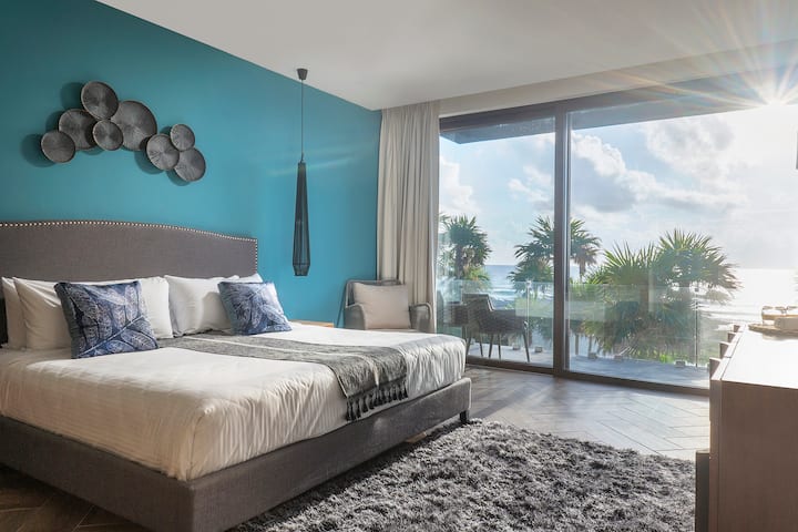Hermosa habitación con una cama tamaño king y una vista al patio y al mar. Precioso balcón privado con muebles cómodos