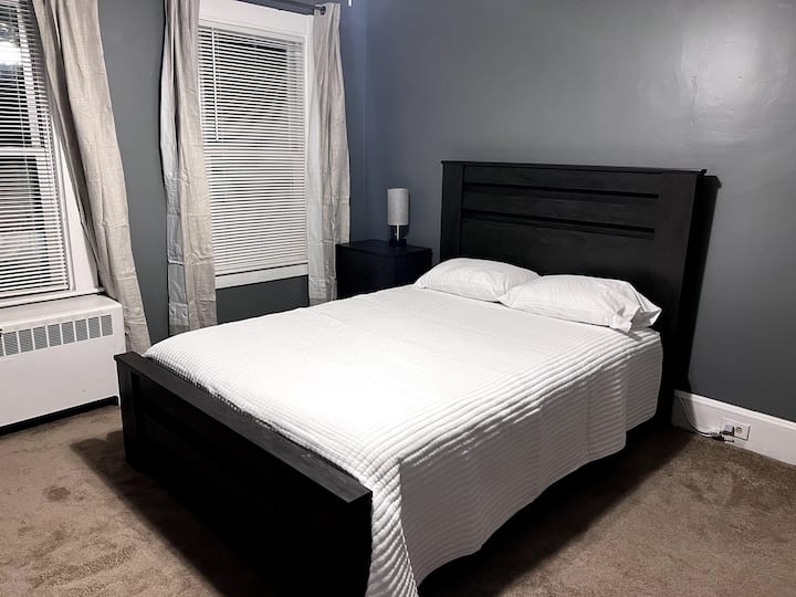 Queen bedroom with darkening curtains and lamp with USB charging ports and a 43" HD TV with streaming capabilities 