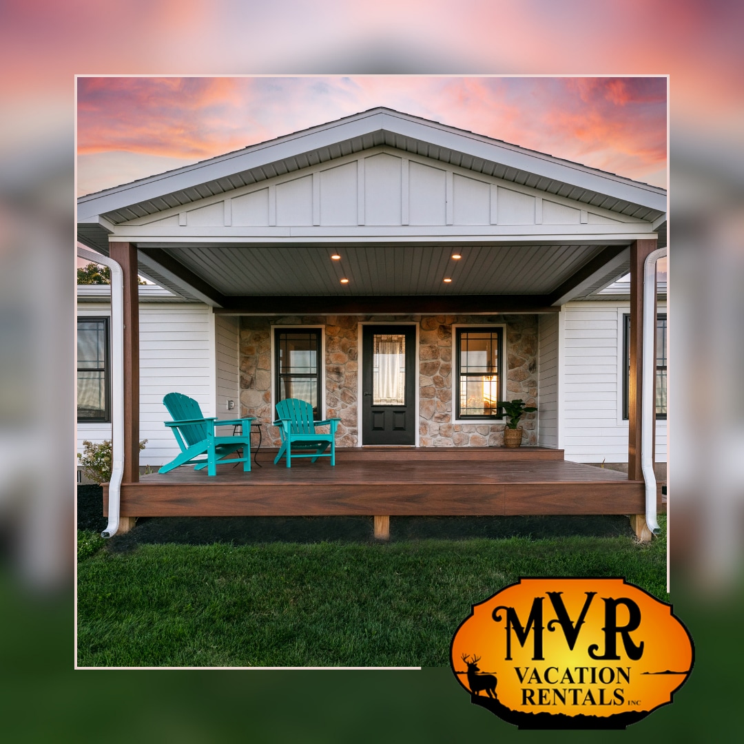 The inviting front porch features two bright blue chairs set on a wooden deck, offering a welcoming spot to relax. The well-maintained lawn frames the entrance, complemented by stone accents on the house's facade, creating a cozy and approachable atmosphere.