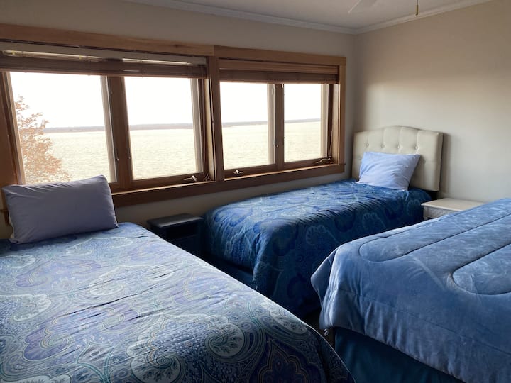 This beautiful bedroom is upstairs and has a wonderful view of the lake.  It has one queen and 2 XL twin beds. There is a full bathroom inside this room.