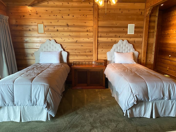 This is the master bedroom on the first floor and has a large vaulted wooden ceiling. 

It has one queen bed and 3 XL twin beds. The master bath is adjacent to this room.