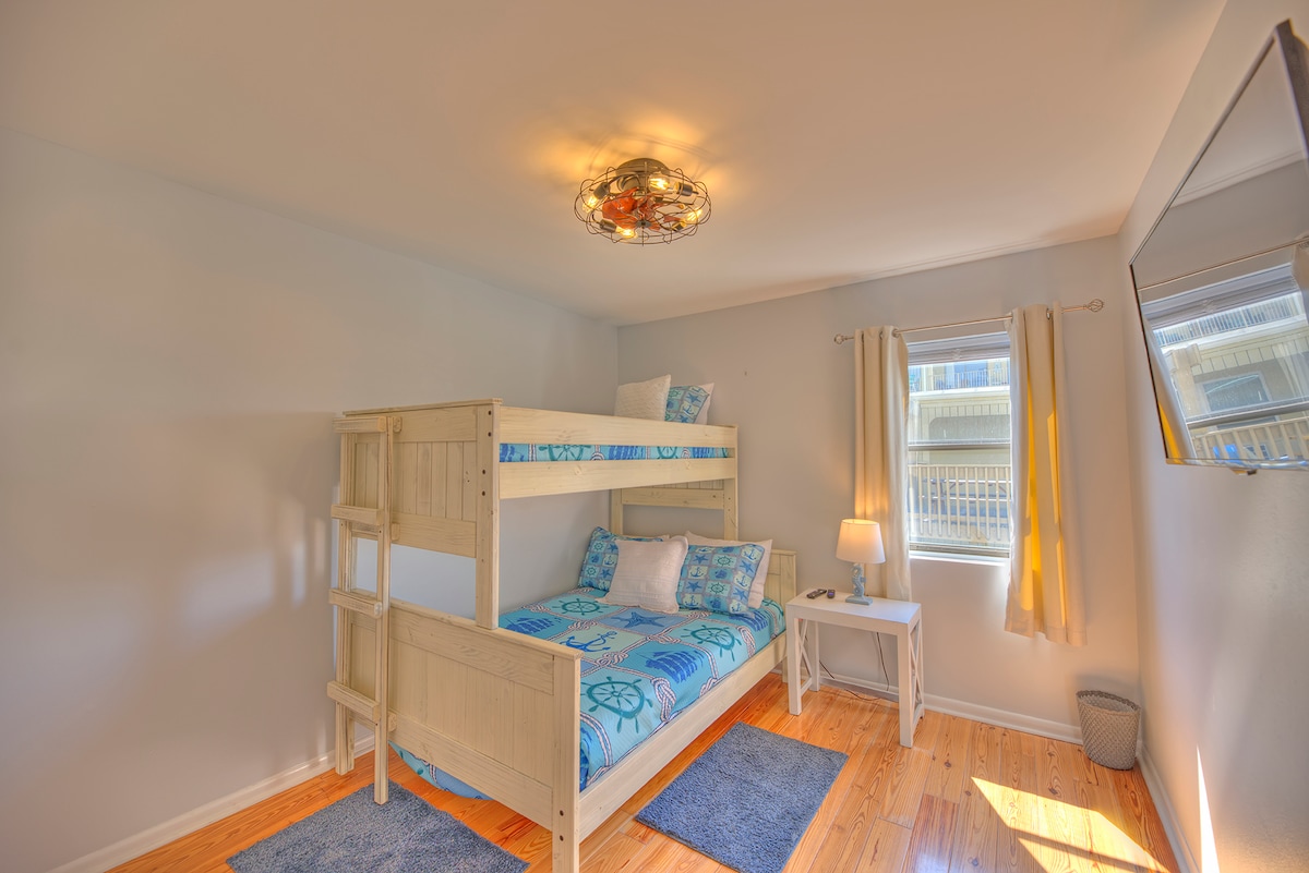 غرفة نوم ثانية - سرير مزدوج على سرير بطابقين مع خزانة. تلفزيون ذكي بشاشة مسطحة مع أرضيات خشبية صلبة