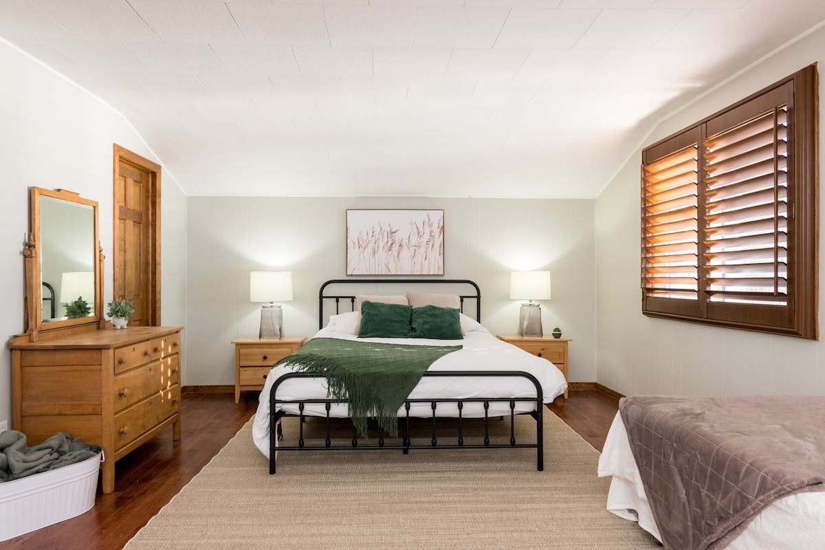 The master bedroom "Lakeview" has a serene and peaceful backdrop. It also has a workspace with two large computer screens.