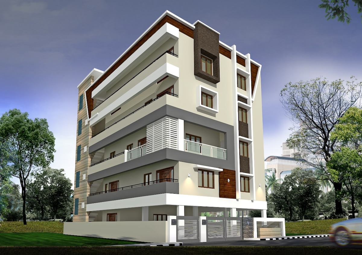 The modern multi-story building features a combination of neutral and natural materials, with well-defined horizontal lines. Balconies extend from various levels, enhancing the structure's contemporary design. Lush greenery surrounds the property, providing a serene environment.