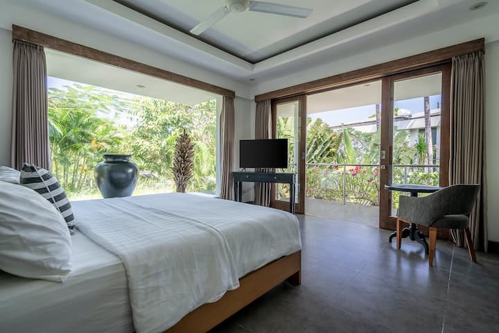Dormitorio 3 con mesa de centro y silla, TV de pantalla plana e impresionantes vistas al jardín