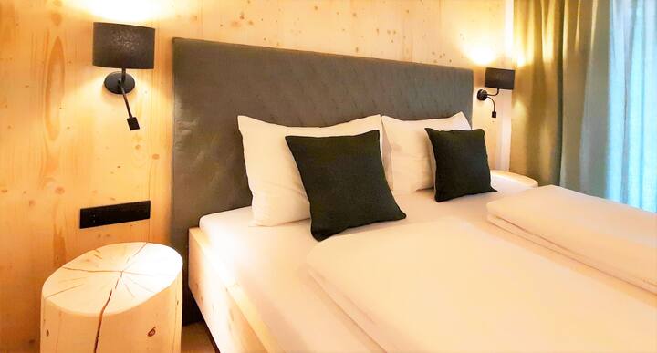 vomLandl Naturloft ZirbenWald.
Habitación doble con cama de madera de pino macizo (180 x 200 cm) con acceso al jardín. Materiales naturales, techo de madera de abeto, troncos de pino, ropa de cama natural y suelos de madera de roble.
Para dormir bien por la noche.