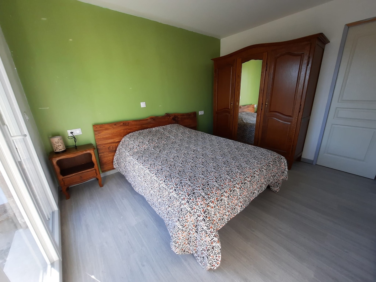 Chumba cha kulala cha malazi ya Iris, kitanda cha sentimita 140 x 190, kabati kubwa la nguo, meza ya kando ya kitanda iliyo na taa.