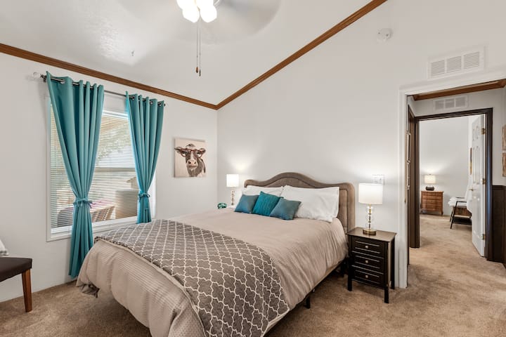 Habitación verde azulado con cama tamaño queen. 