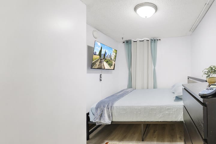 Relax in this cozy bedroom featuring a plush bed and a flat-screen TV for your entertainment.
