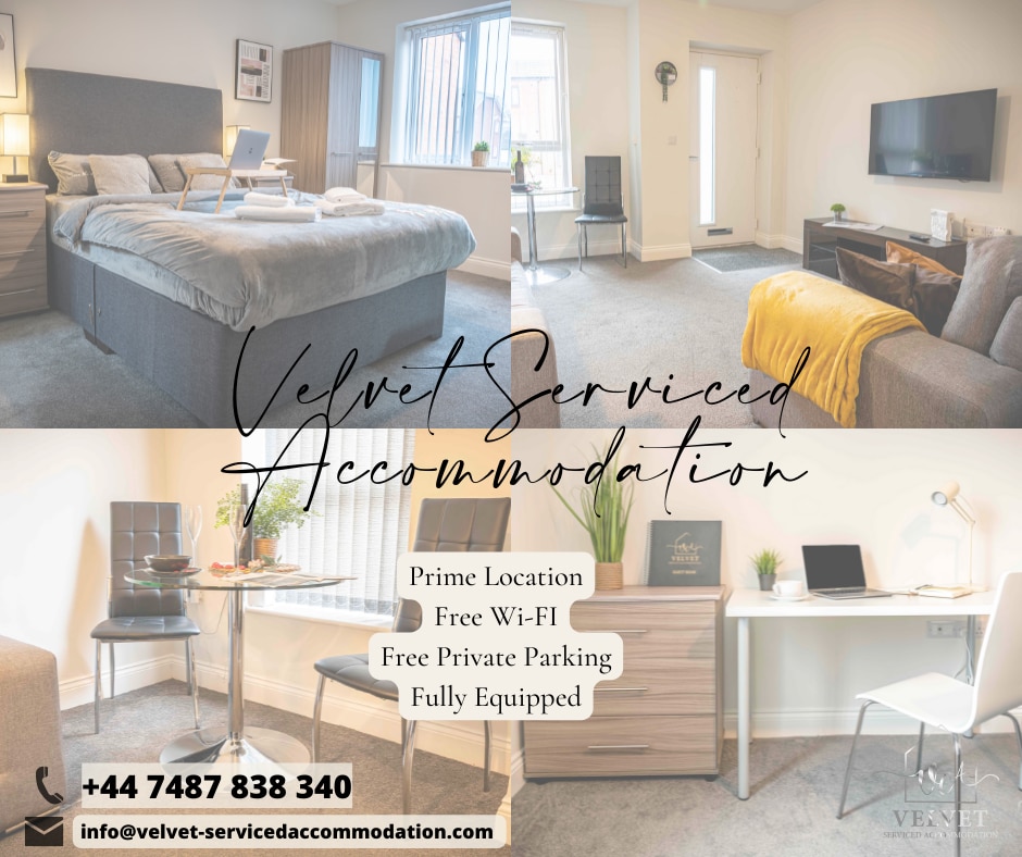 A spacious apartment is displayed, showcasing a comfortable king-size bed with soft linens. A wooden desk and chair are positioned, complemented by natural light entering through large windows. A television is mounted on the wall, creating a cozy living space suitable for various stays.